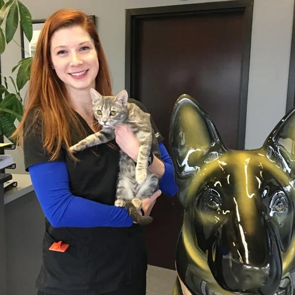 Maddie smiling and holding striped tabby cat