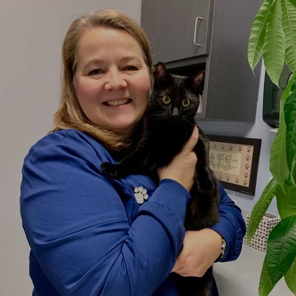 Tracy smiling and hugging black cat